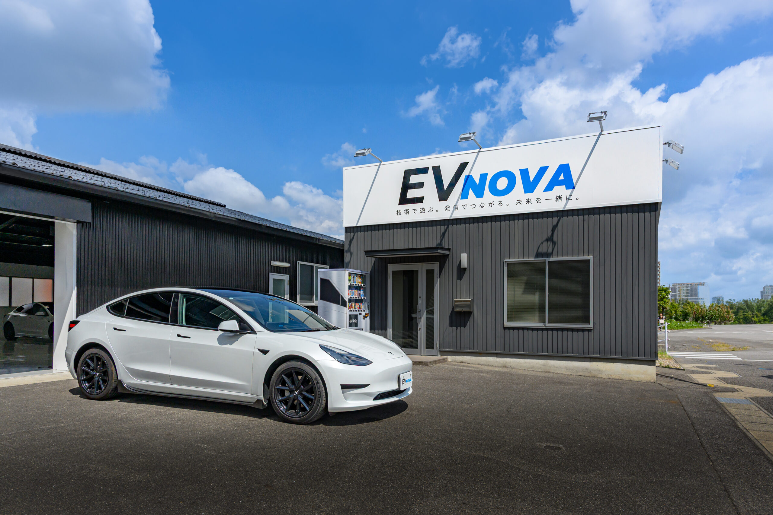 EV NOVA 名古屋本店と白いテスラ Model 3